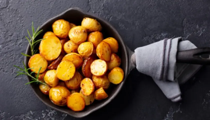 Patatas doradas y crujientes en una sartén, listas para servir. Un toque de romero realza el aroma de estas patatas olla express.
