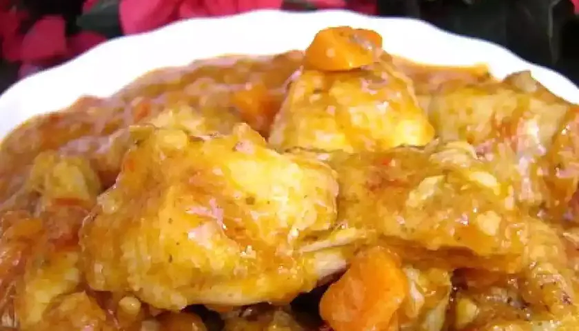 Sabroso pollo al chilindrón arguiñano, con trozos de pimiento y tomate en una salsa dorada.