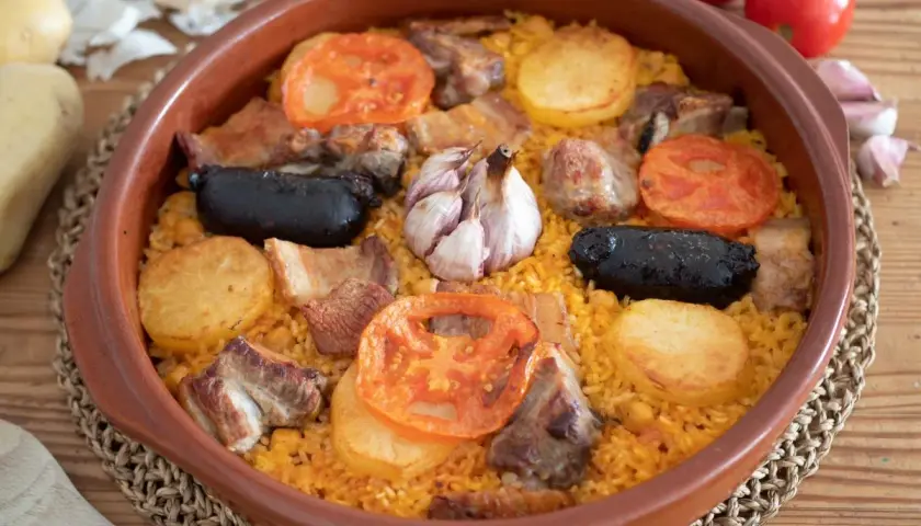 Arroz al horno con costillas, morcilla, patatas y tomates. El tiempo y temperatura perfectos para un plato delicioso.