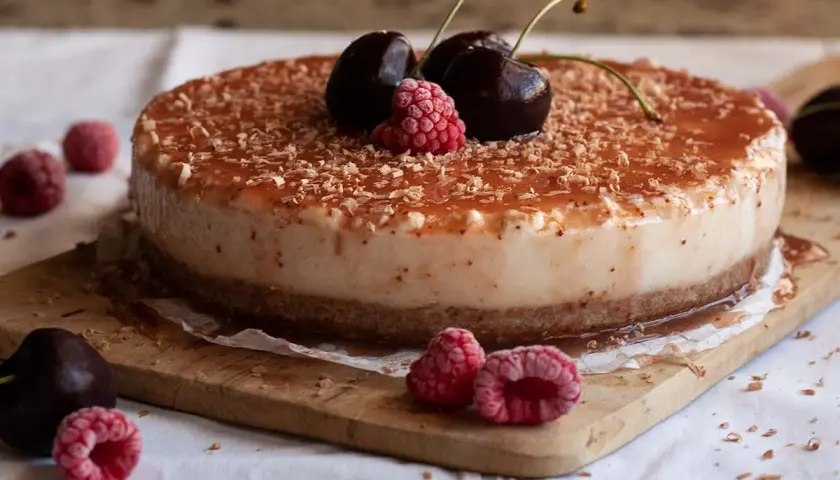 Tarta de queso con leche condensada, cubierta de frutos rojos y virutas de chocolate. ¡Un postre irresistible!