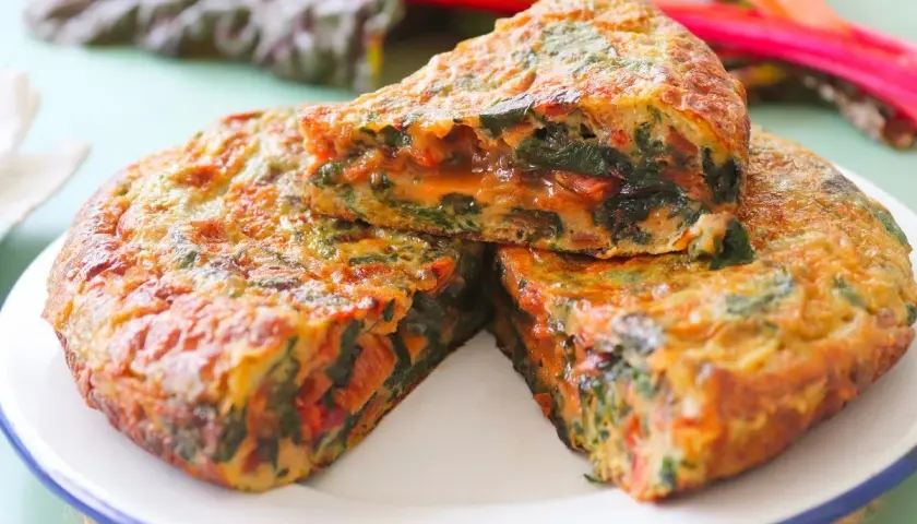Tortilla de acelgas casera, jugosa y dorada, con trozos de verdura bien integrados.