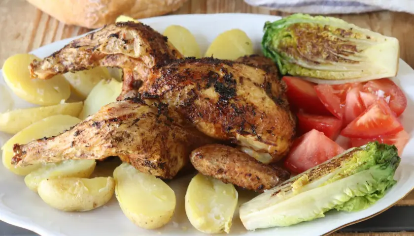 Pollo a la brasa jugoso y dorado, acompañado de papas amarillas, tomates frescos y lechuga a la parrilla. Un festín para disfrutar.