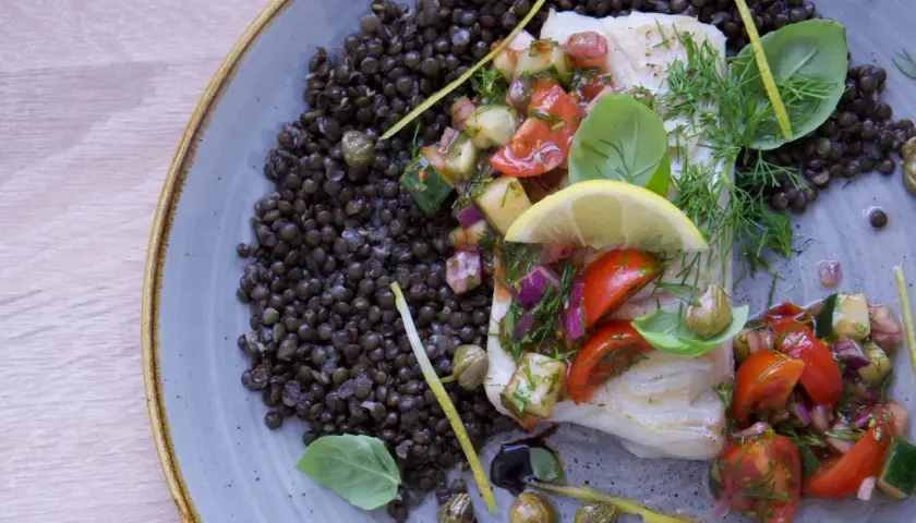 Filete de bacalao con ensalada de tomate y pepino, acompañado de lentejas. Una de las mejores recetas de bacalao.