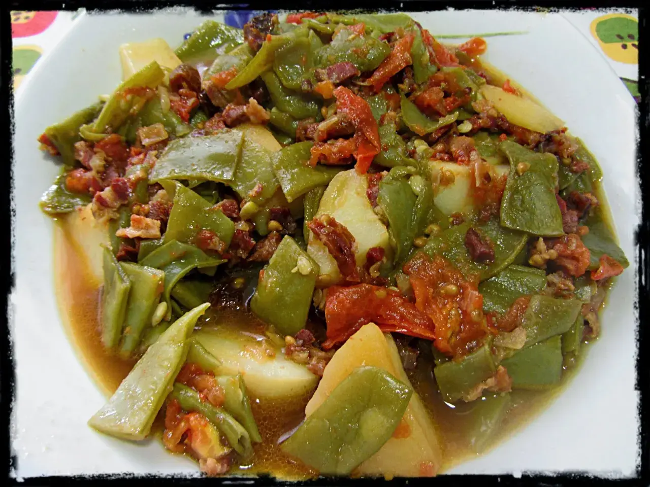 Judías verdes tiernas con patatas y trocitos de jamón, cocinadas en olla express. Un plato casero y sabroso.