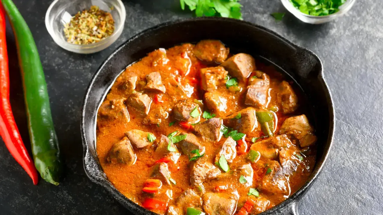 Sabroso pollo guisado arguiñano en sartén, con pimientos y especias. ¡Un plato casero que huele delicioso!