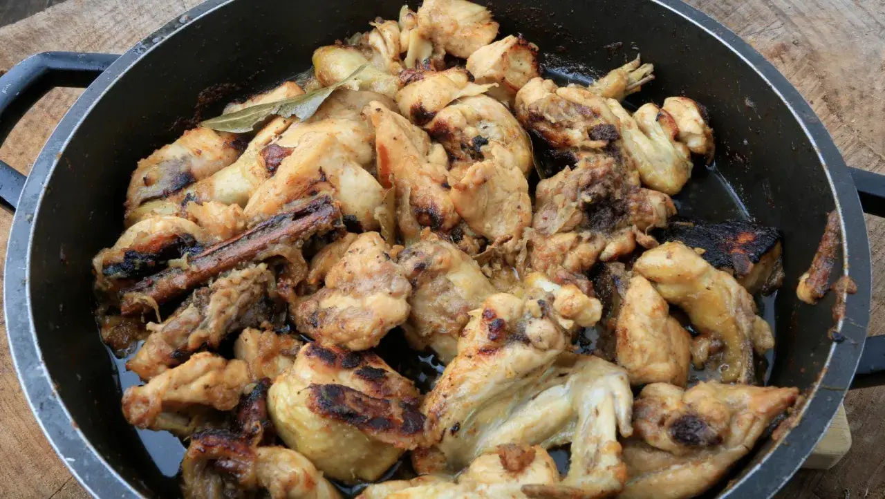 Sabroso pollo al ajillo arguiñano en sartén, con trozos dorados y jugosos, listos para disfrutar.
