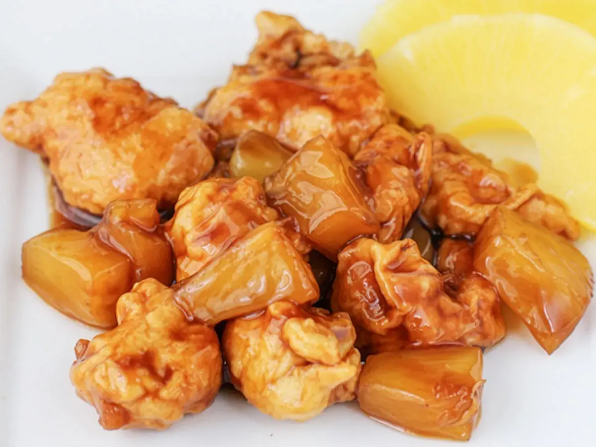 Sabroso pollo con piña en salsa agridulce, con trozos de piña dorada y jugosa.