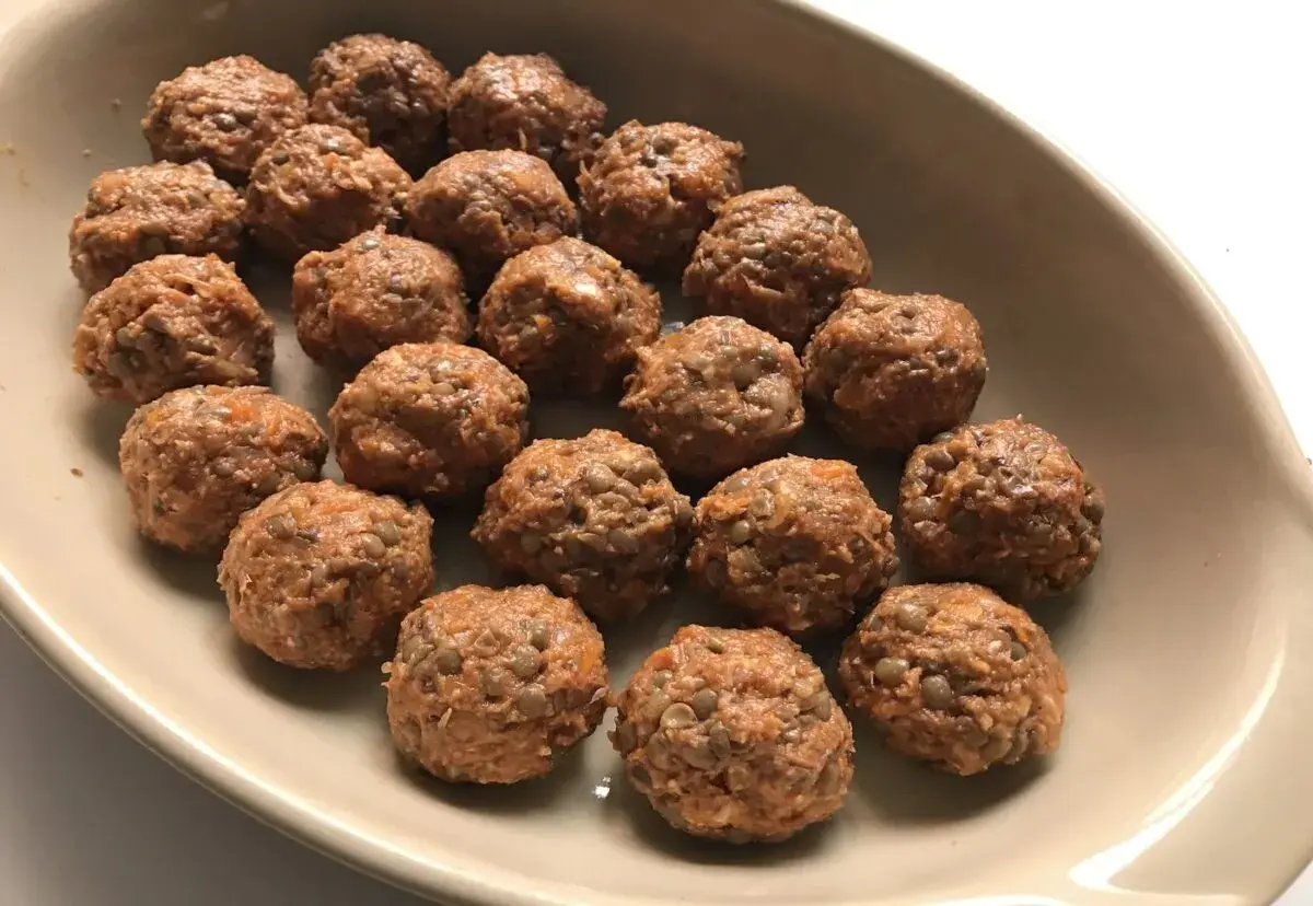 Albondigas de lentejas listas para hornear en una bandeja.