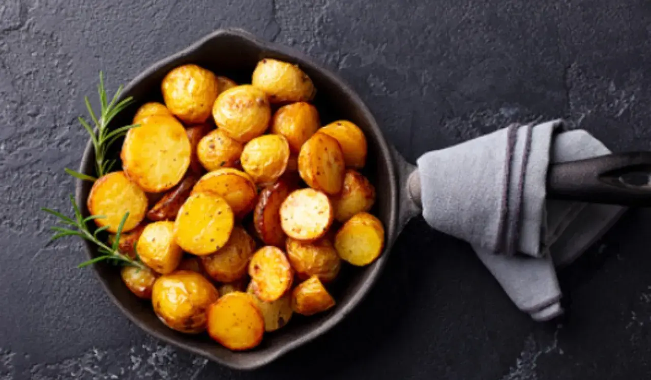 Patatas doradas y crujientes en una sartén, listas para servir. Un toque de romero realza el aroma de estas patatas olla express.
