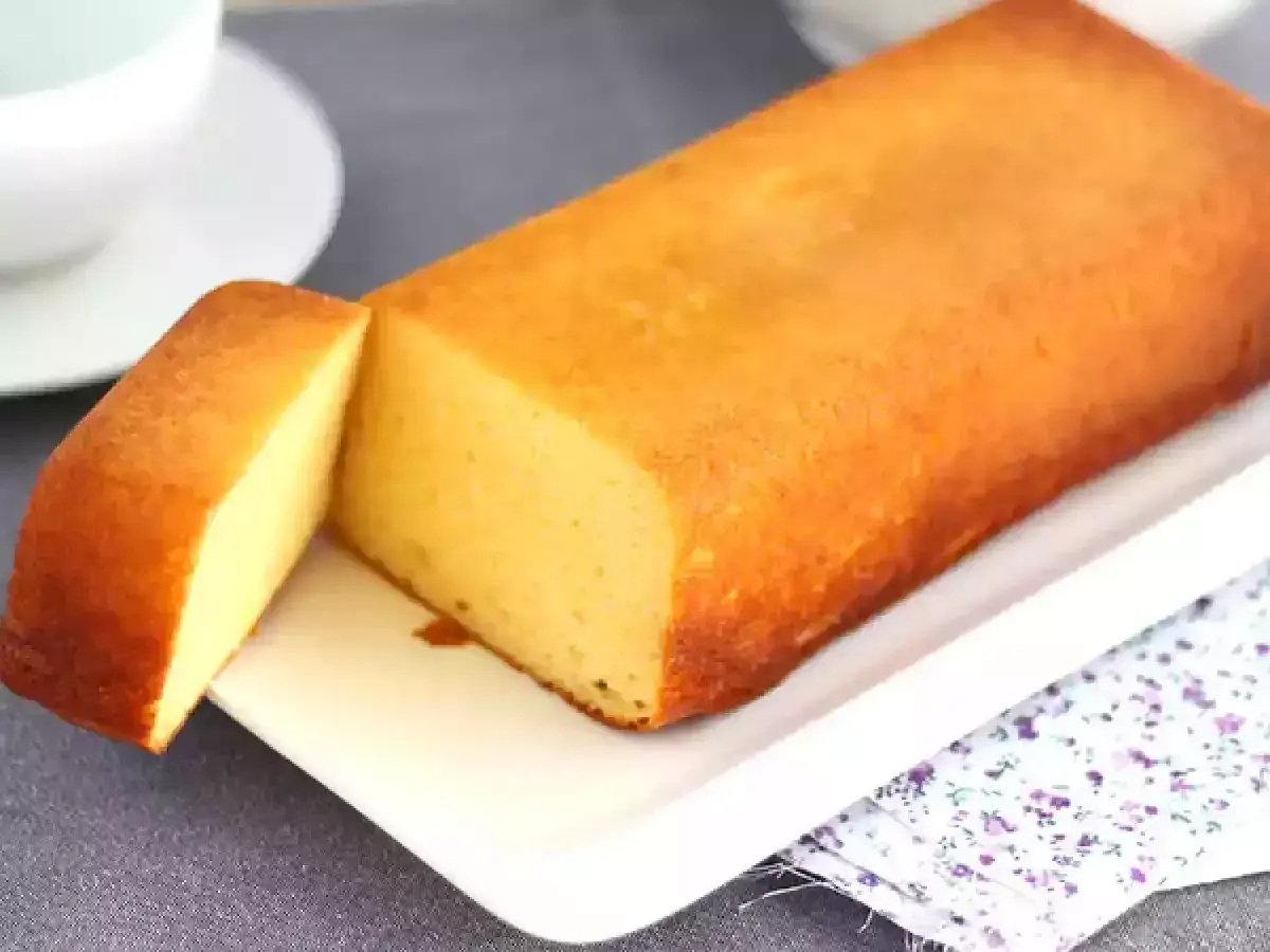 Un delicioso bizcocho de leche condensada, dorado y esponjoso, servido en una bandeja blanca.