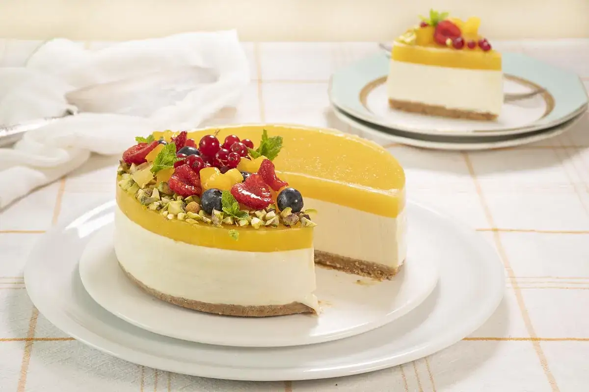 Tarta de mango con frutos rojos y pistachos, una delicia tropical.