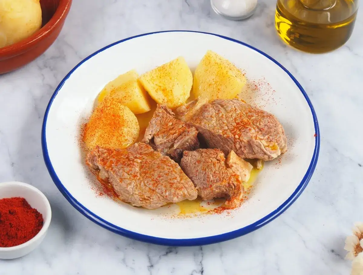 Sabroso plato de carne o caldeiro con patatas cocidas, espolvoreado con piment&oacute;n y un chorrito de aceite de oliva.