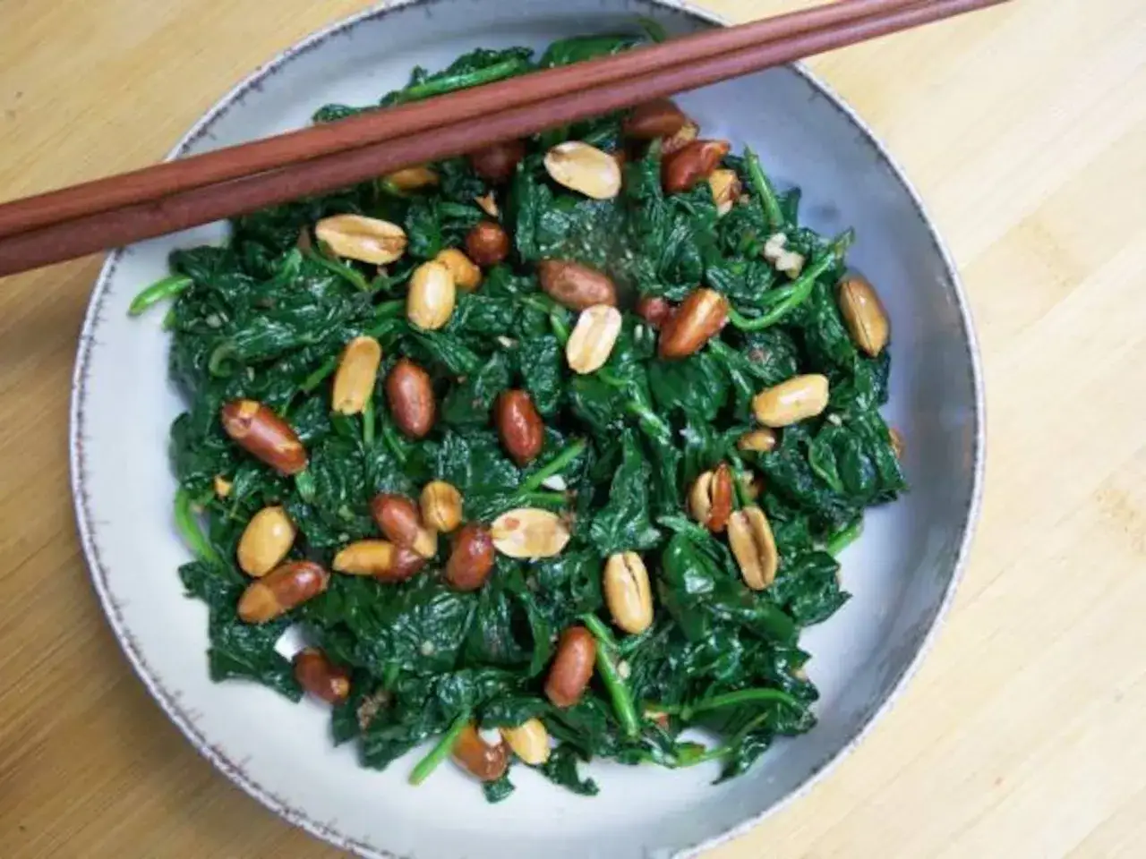 Espinacas salteadas con cacahuetes, listas para comer. El tiempo cocci&oacute;n espinacas es corto para mantener su frescura.