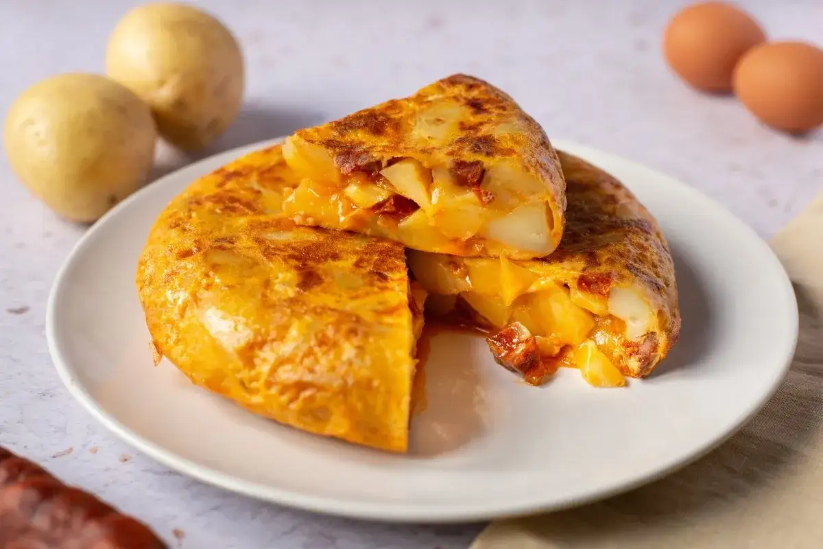 Una jugosa tortilla de chorizo, con patatas tiernas y trocitos de chorizo, lista para disfrutar.