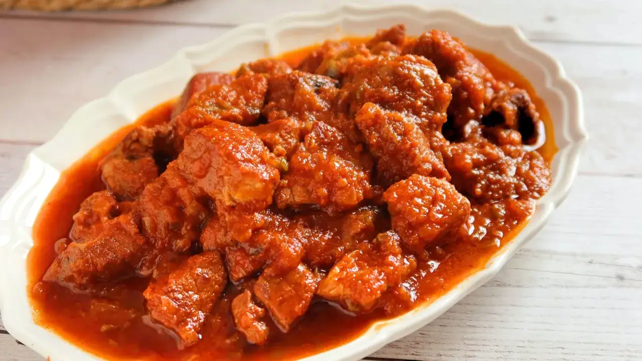 Magro con tomate, la receta de la abuela, servido en un plato blanco.
