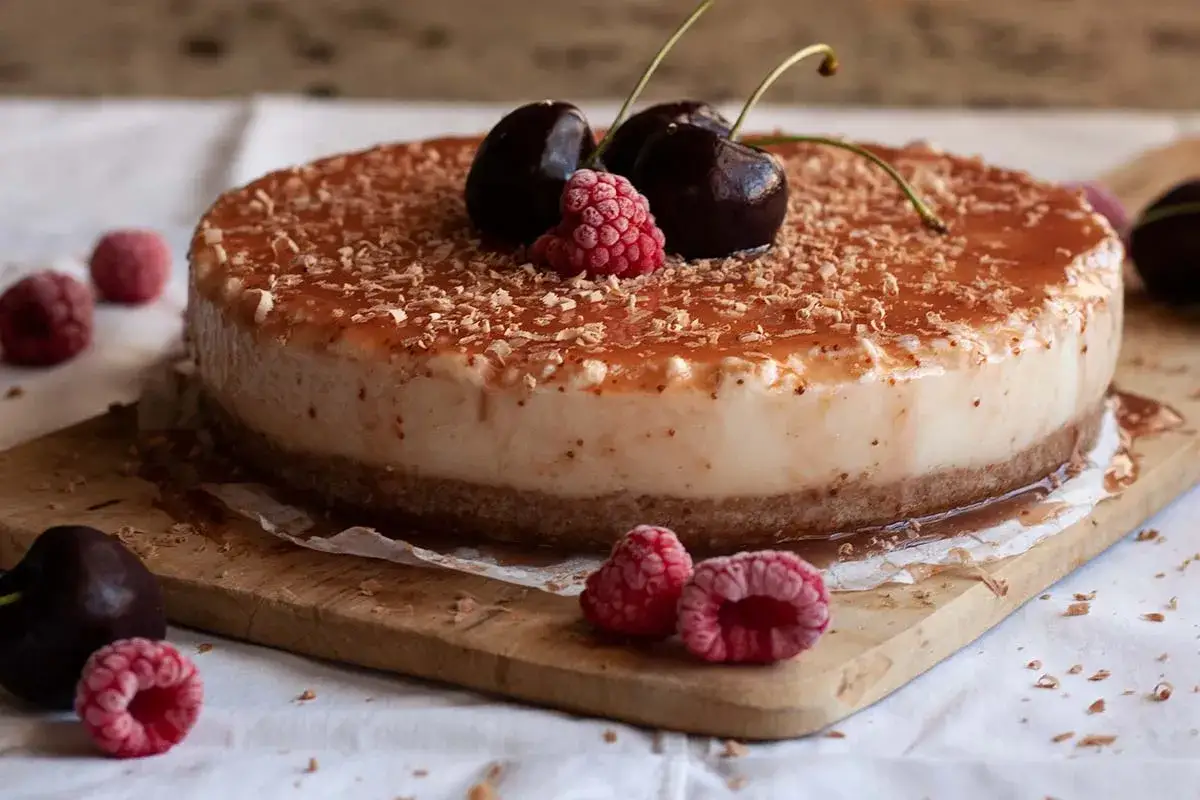 Tarta de queso con leche condensada, cubierta de frutos rojos y virutas de chocolate. &iexcl;Un postre irresistible!