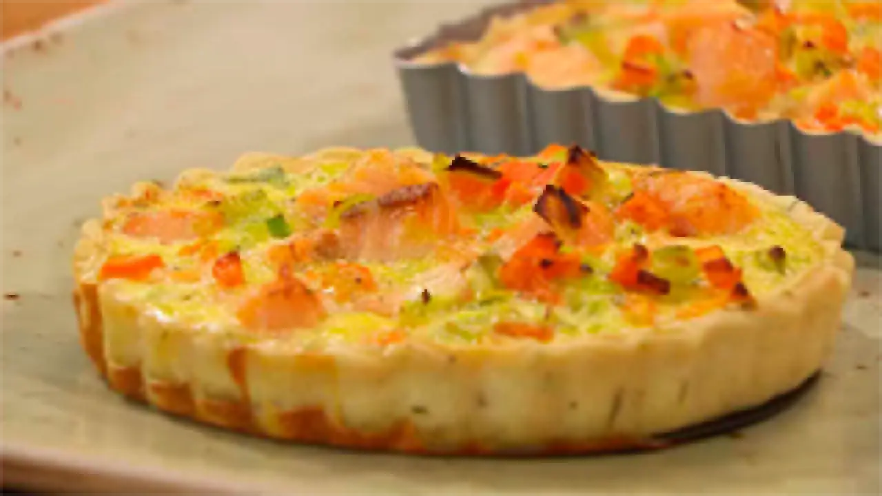 Delicioso pastel de puerros con salm&oacute;n y verduras, horneado en un molde acanalado.