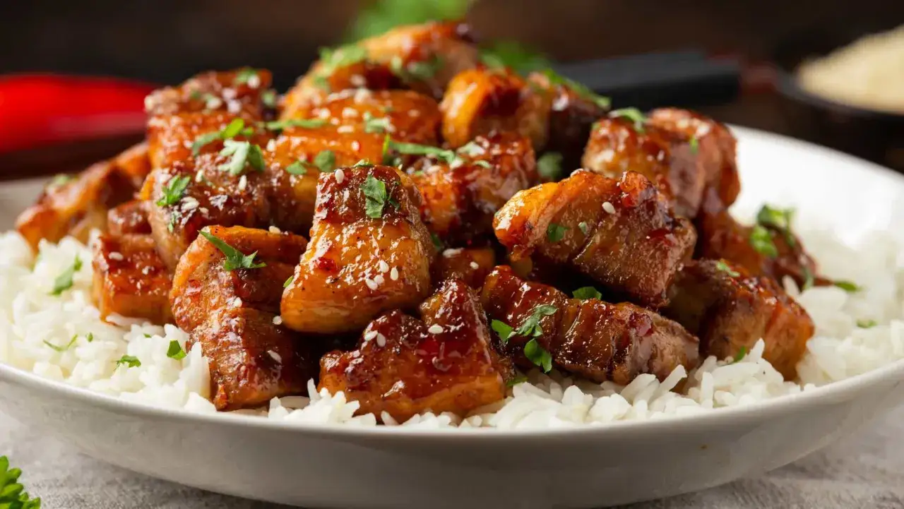 Carne guisada arguiñano, jugosos trozos de carne glaseada con sésamo y perejil sobre una cama de arroz blanco.