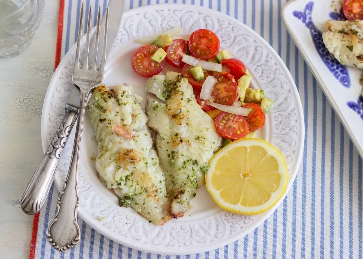 Deliciosa gallineta a la plancha con ensalada de tomate y aguacate, acompa&ntilde;ada de un gajo de lim&oacute;n.