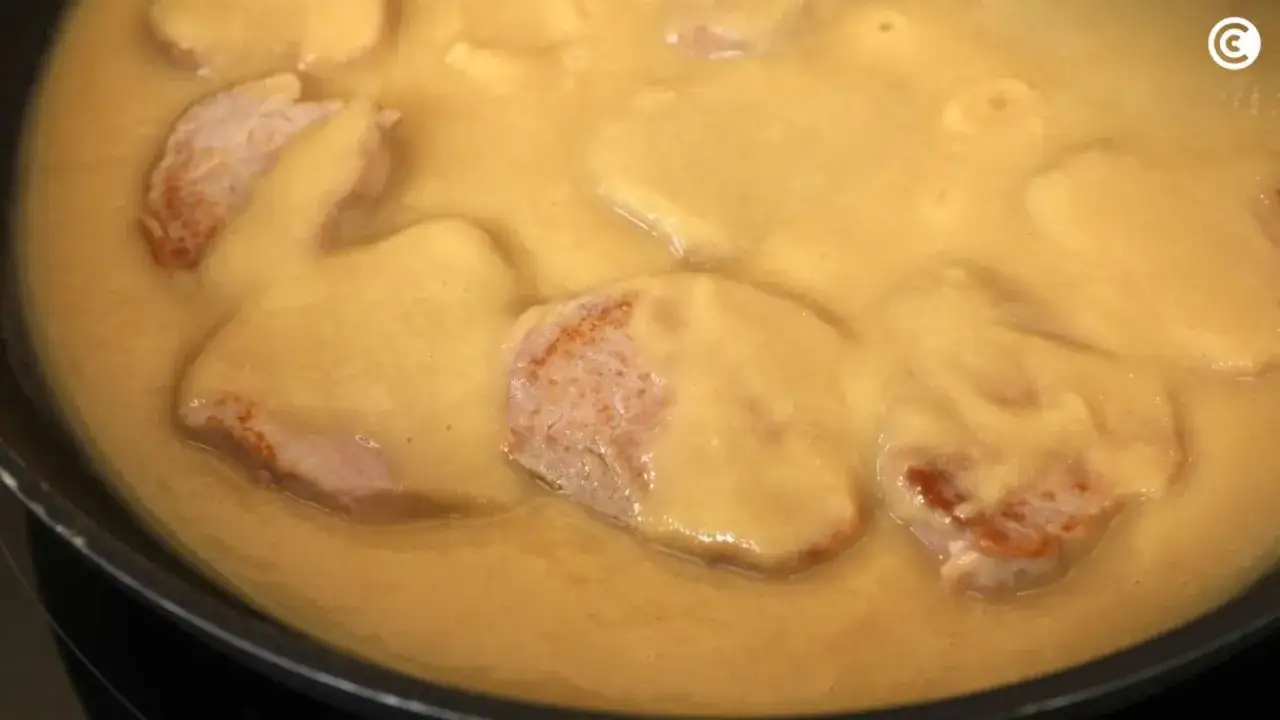 Filetes de cerdo en una salsa cremosa y dorada, perfecta para aprender como espesar una salsa.