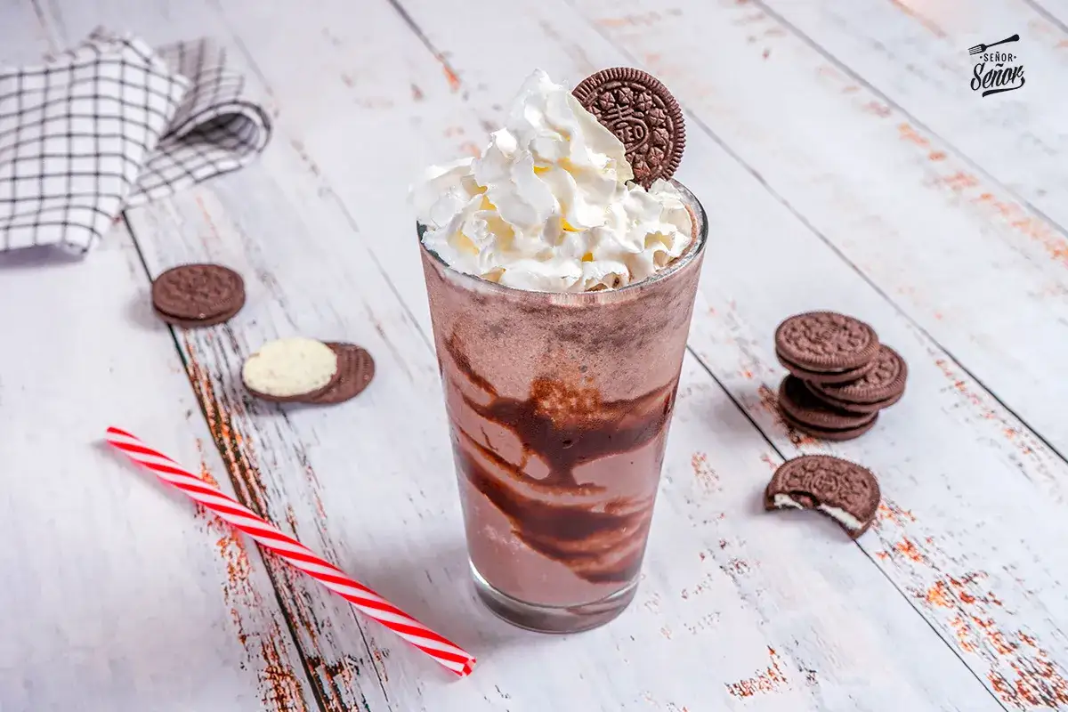 Delicioso batido de oreo con crema batida y galletas, listo para disfrutar.