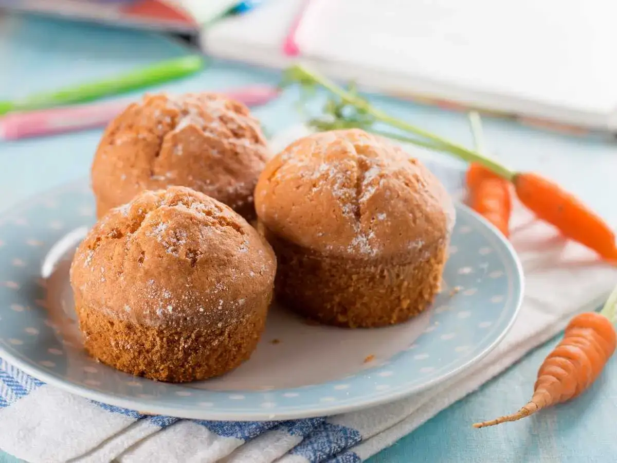 Deliciosas magdalenas de zanahoria, recién horneadas y espolvoreadas con azúcar glas. Perfectas para un tentempié saludable.