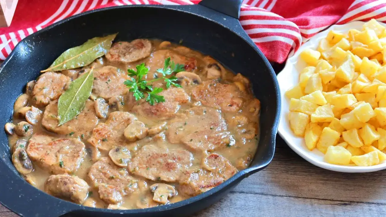 Solomillo en salsa de la abuela con champiñones y laurel, acompañado de patatas fritas. Un plato casero que evoca recuerdos.
