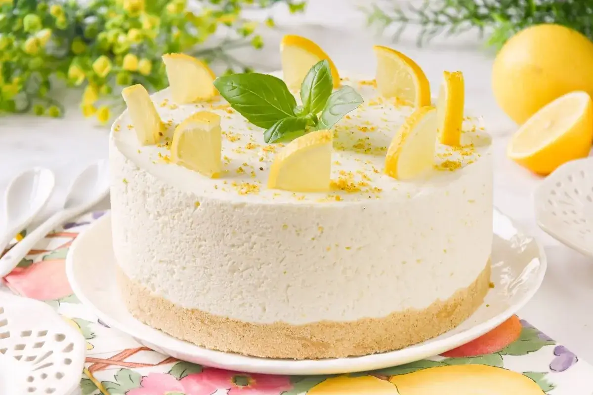 Delicioso mousse de limón, decorado con rodajas de limón y hojas verdes.