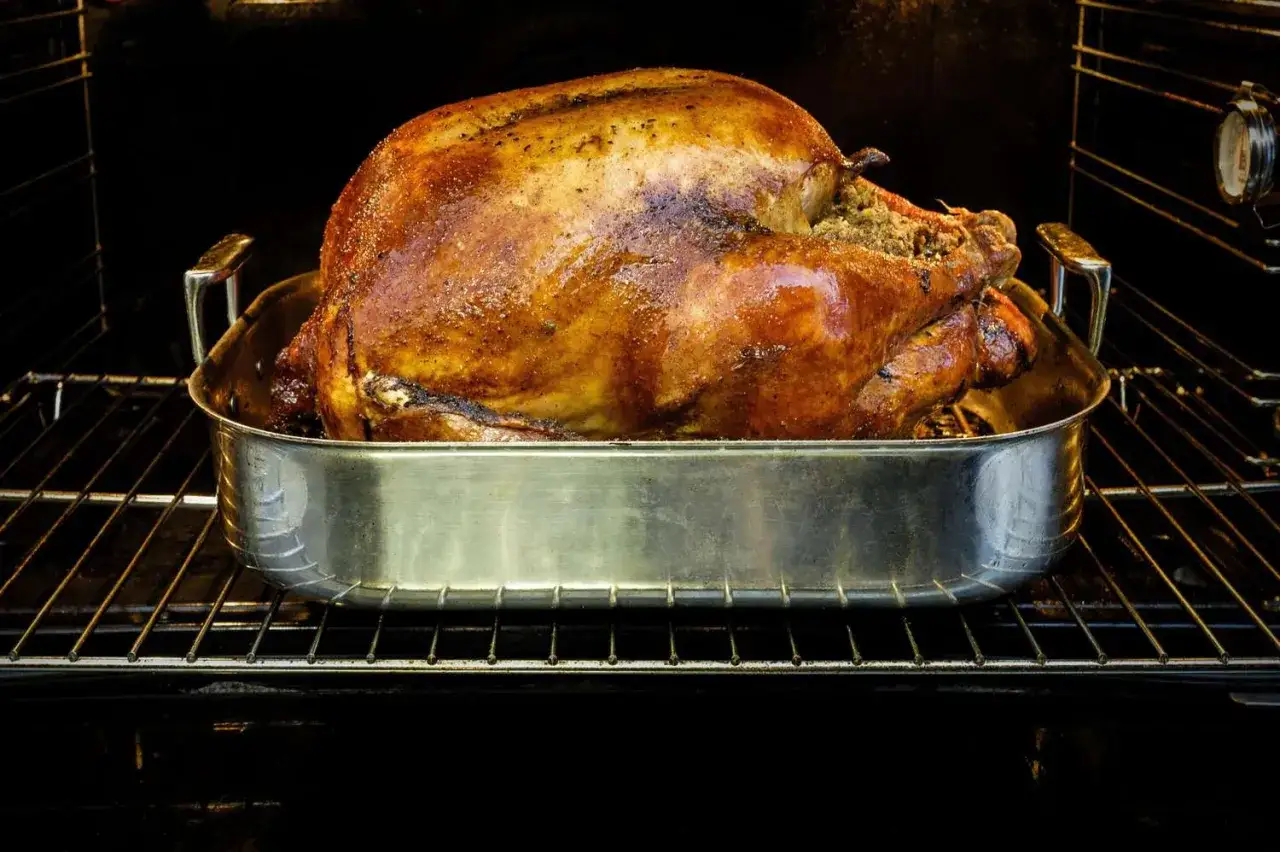 Un jugoso solomillo de pavo al horno, dorado y listo para servir, descansa en su bandeja metálica dentro del horno.