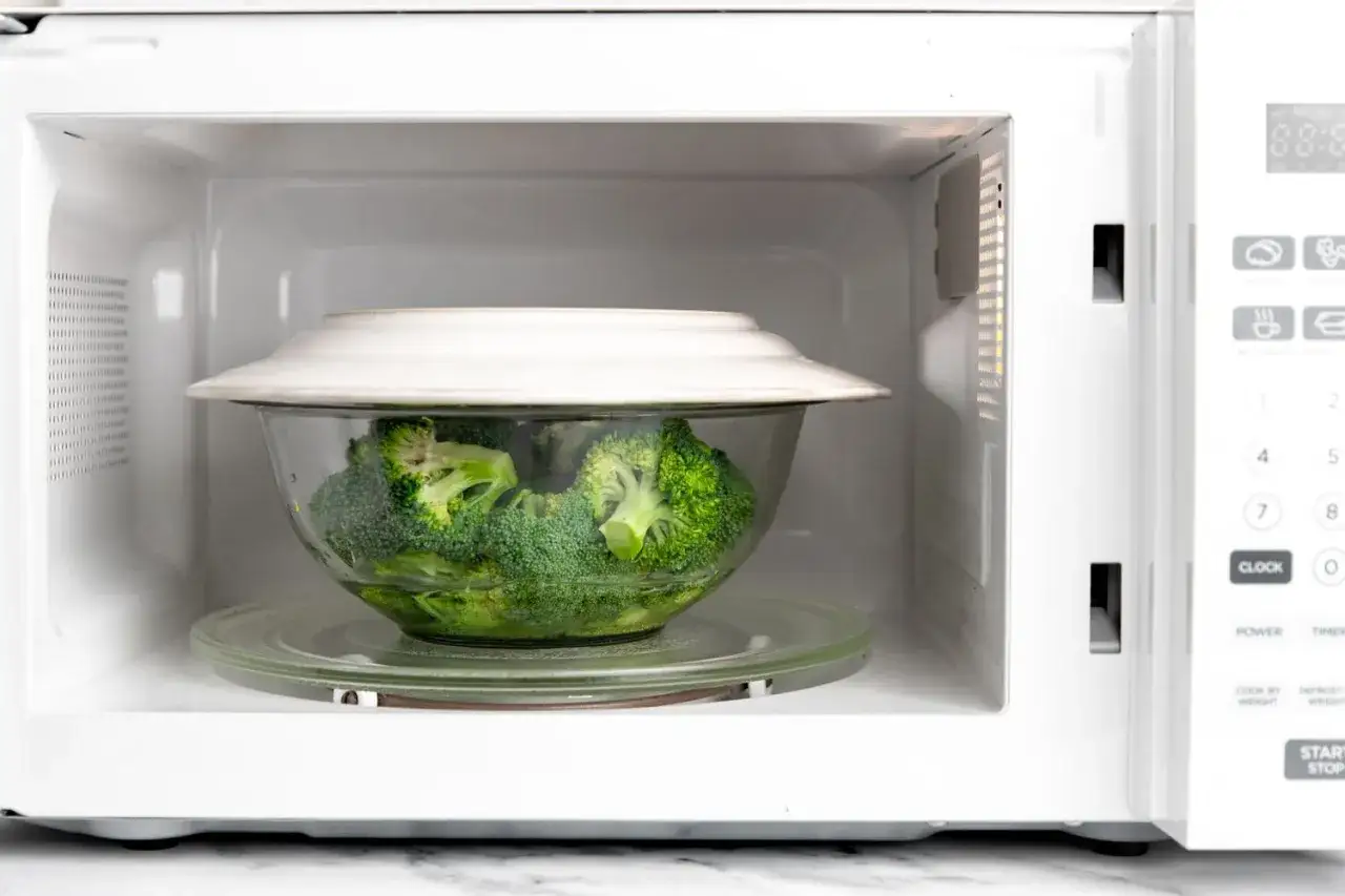Brocoli al microondas en un bol de cristal, listo para cocinar.