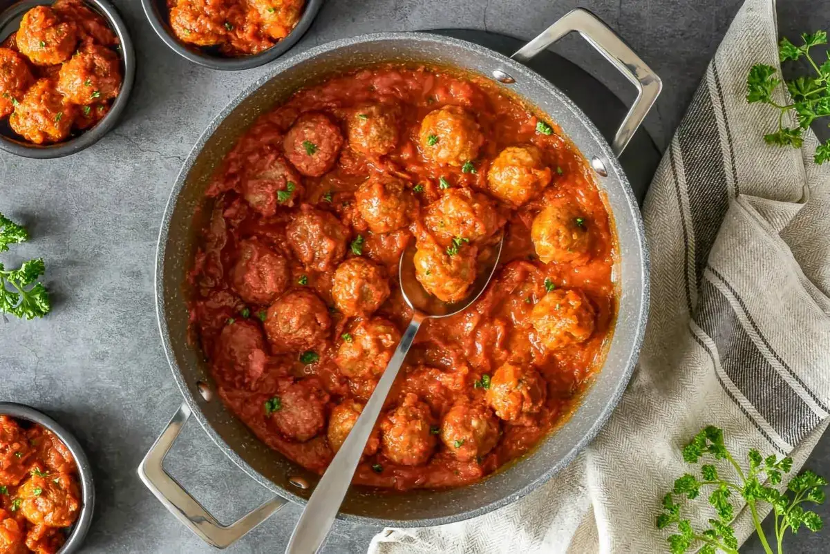 Sabrosas alb&oacute;ndigas en salsa roja, listas para servir. Un plato casero que invita a disfrutar.