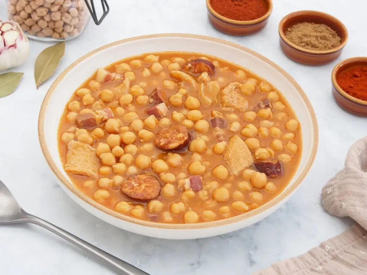 Un plato humeante de callos a la gallega, con garbanzos, chorizo y trozos de panceta, listo para disfrutar.