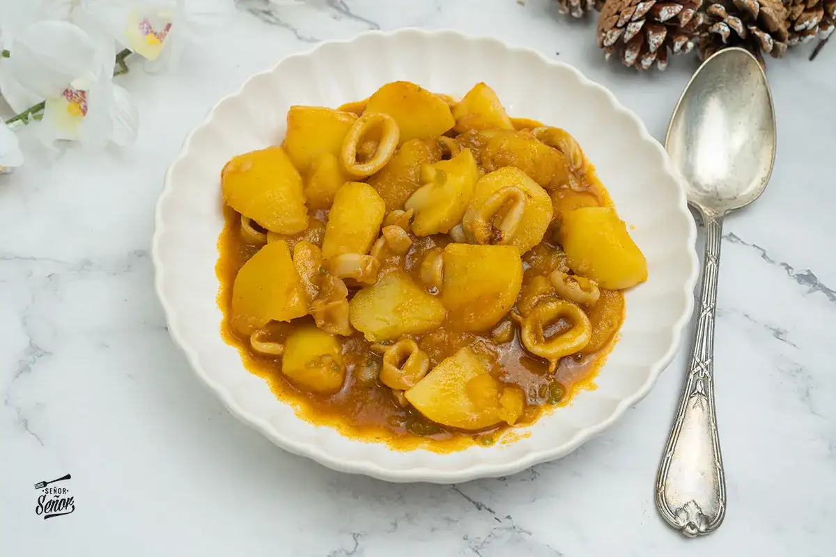 Plato de patatas con calamares arguiñano, un guiso casero lleno de sabor.