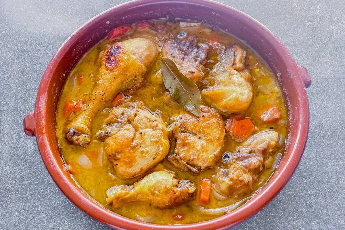 Pollo guisado en cazuela de barro, con zanahorias y laurel. Un plato que recuerda a las recetas de pollo en salsa de la abuela.