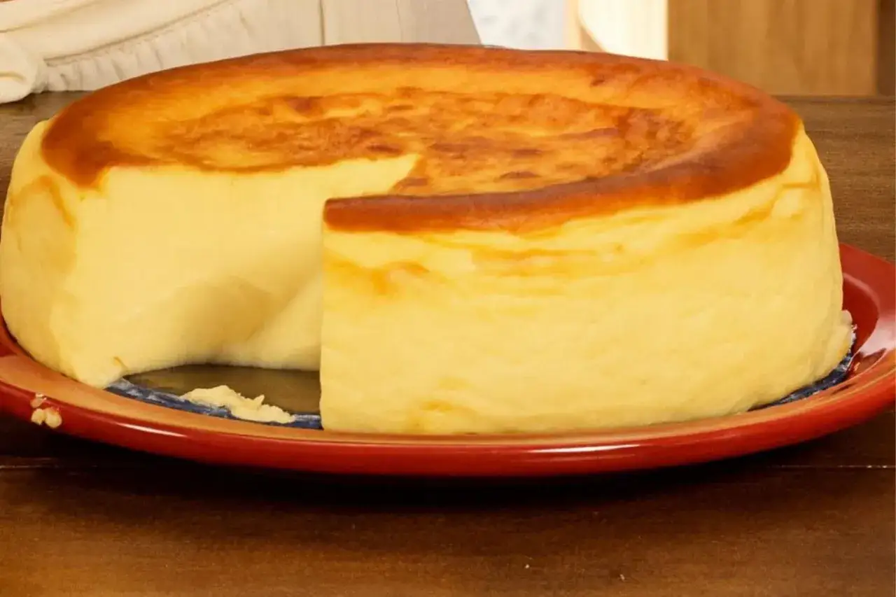 Tarta de queso cremosa, dorada y deliciosa, con una porción retirada para deleitar.